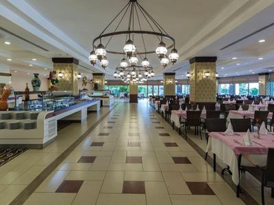 Ampia sala da pranzo con area buffet e tavoli apparecchiati in un hotel.
