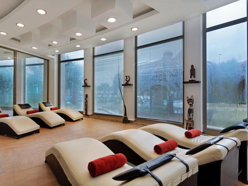 Moderne wellnessruimte met ligstoelen en grote ramen voor een ontspannen verblijf.