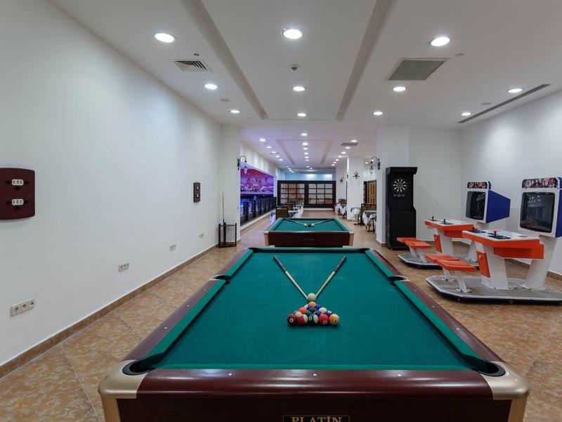 Speelruimte met pooltafels en fitnessapparatuur in een lichte, moderne ruimte.