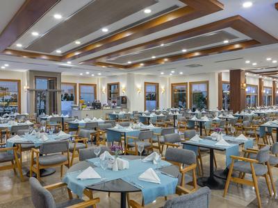Ampia sala da pranzo moderna con tavoli apparecchiati e sedie comode.