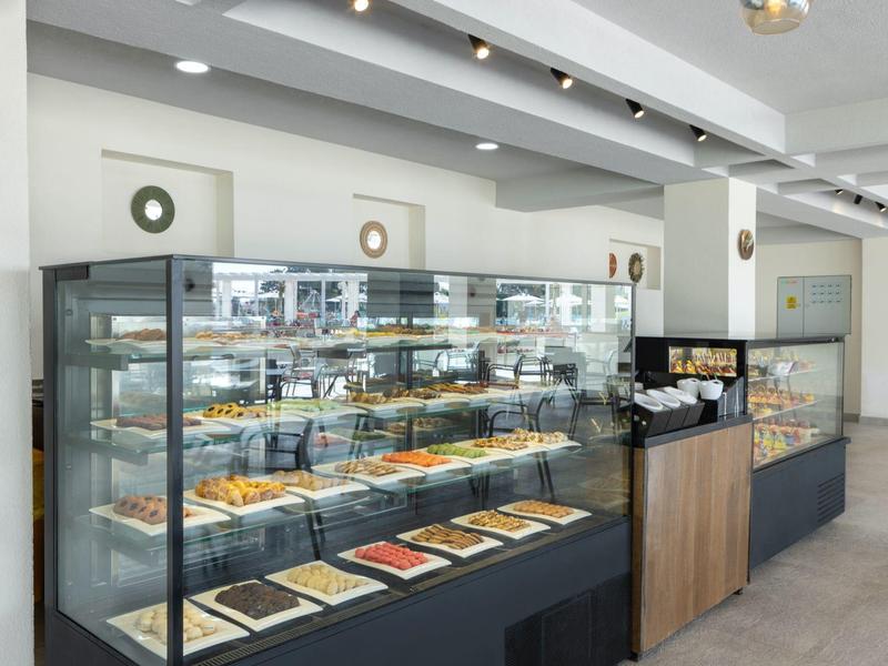 Modern bakery with illuminated display cases filled with various baked goods and minimalist decor.