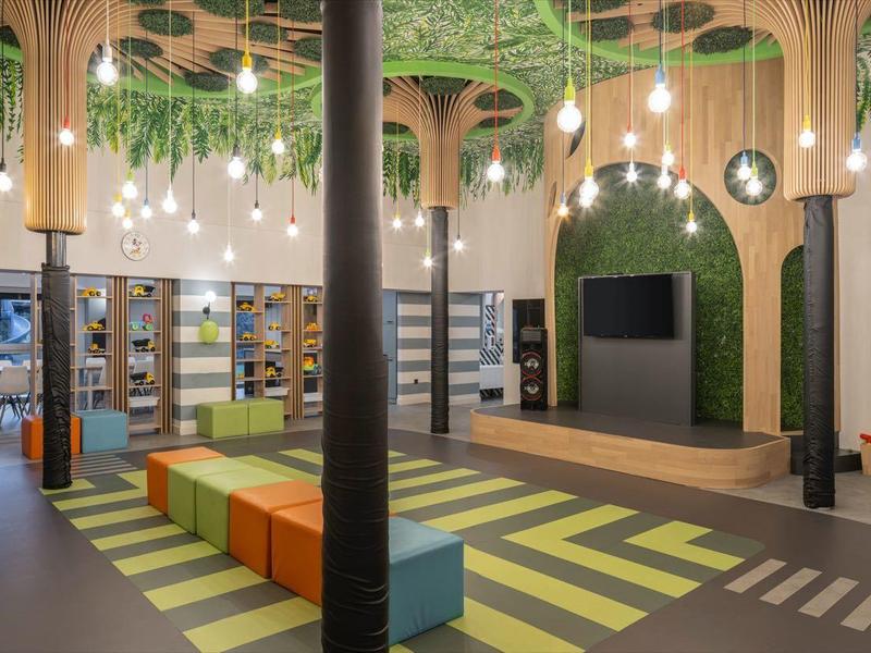 Modern hotel lobby with colorful geometric seating and hanging green plants