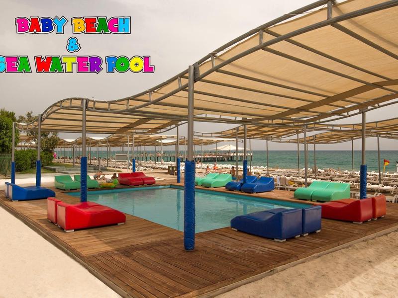 Überdachter Spielbereich mit Sitzsäcken und Spielmatten am Strand mit Blick aufs Meer