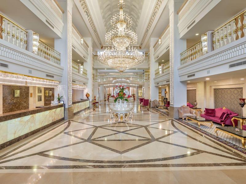 Große Hotelhalle mit Marmorfußboden, Kronleuchtern und eleganten Sitzbereichen