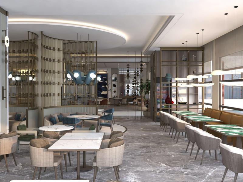 Espace lounge d'hôtel moderne avec fauteuils confortables, canapés et tables aux tons neutres.