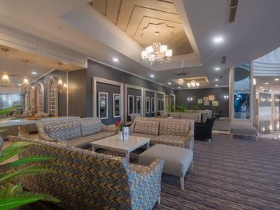 Eleganter Hotel-Lobbybereich mit gemütlichen Sitzgruppen, Kronleuchtern und modernem Ambiente.