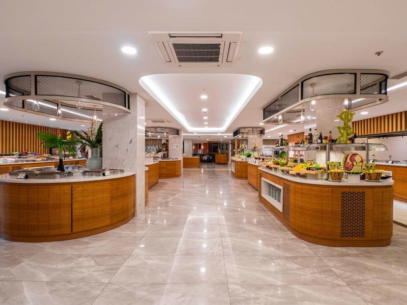 Amplia zona de buffet moderna con oferta variada y diseño elegante en tonos cálidos.