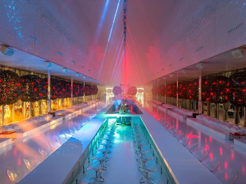 Modern verlichte binnenruimte met kleurrijke lichten en reflecterende oppervlakken.