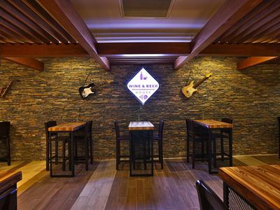 Intérieur chaleureux d'un bar avec tables en bois, chaises et éclairage doux.
