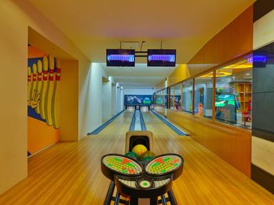 Moderní bowlingová dráha se dvěma dráhami, zrcadlovou stěnou a barevným bowlingovým setem.