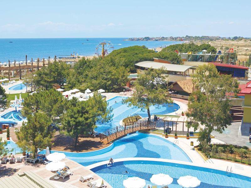 Musicians perform live on stage with the illuminated Sueno Hotels Beach Side logo in the background.
