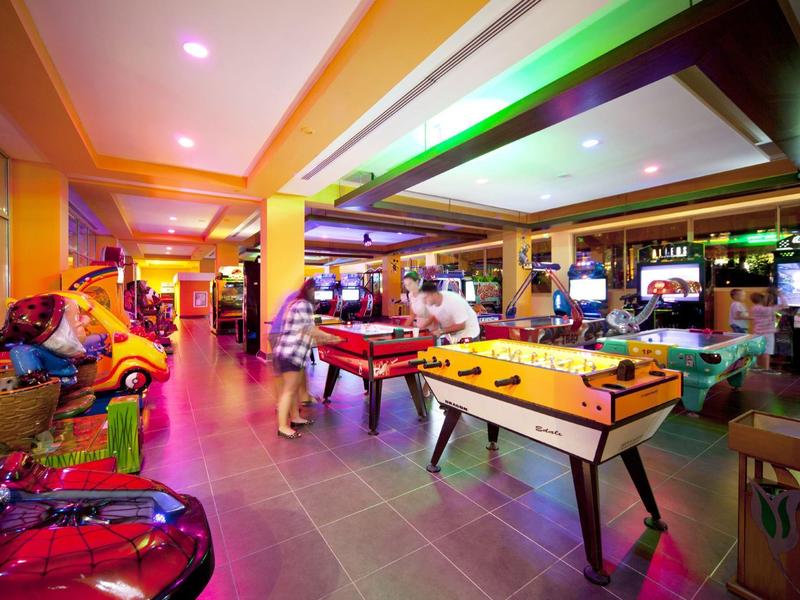 Colorful arcade in a hotel lobby with pinball machines and air hockey table.