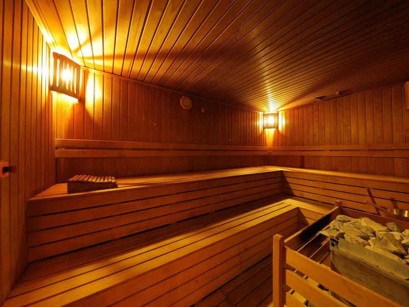 Cozy sauna room with wooden benches and warm lighting.