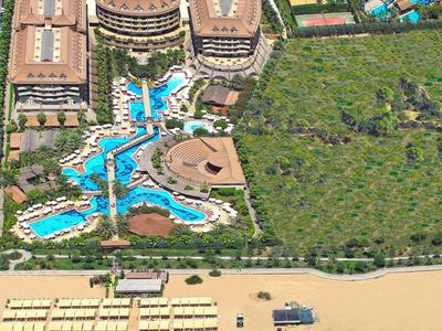 Complexe hôtelier avec piscines, plage sableuse et espaces verts.