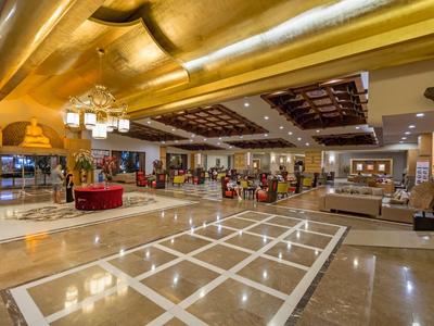 Hall d'hôtel spacieux avec sol en marbre brillant, mobilier confortable et éclairage moderne.