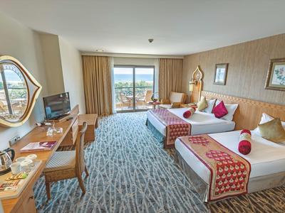 Modern eingerichtetes Hotelzimmer mit zwei Betten, Schreibtisch und Aussicht auf die Stadt.