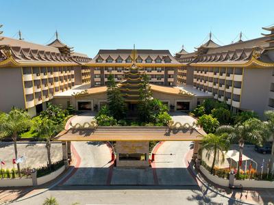 Großes Hotel mit mehrstöckigen Gebäuden und tropischer Vegetation unter blauem Himmel.