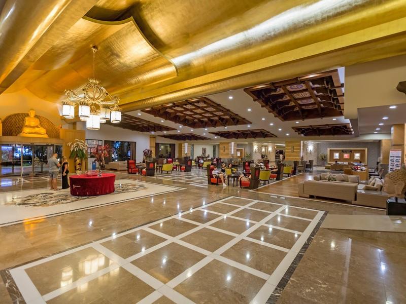 Hall d'hôtel spacieux avec sol en marbre brillant, mobilier confortable et éclairage moderne.