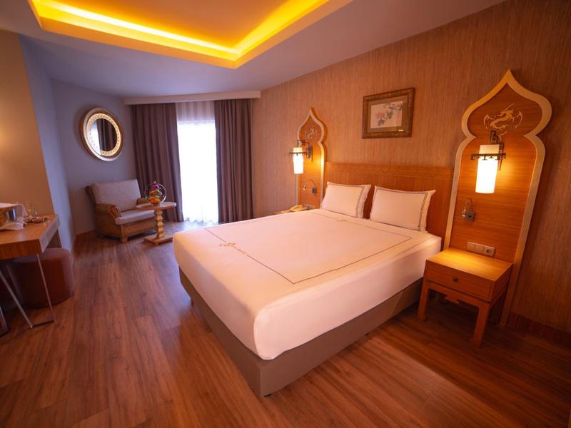 Chambre d'hôtel moderne avec lit double, éclairage chaud et meubles en bois.