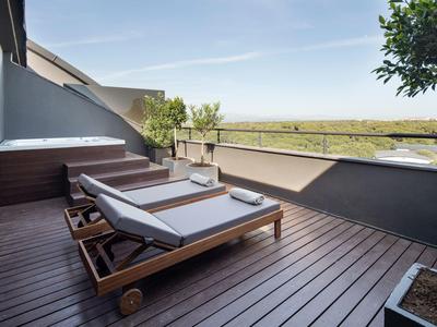 Terraza con dos tumbonas de madera y vista a un paisaje natural, ideal para relajarse.