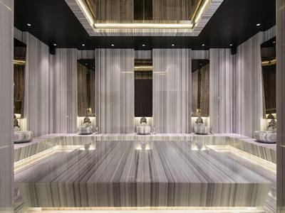 Spa lujoso revestido en mármol con iluminación suave y lámparas elegantes.