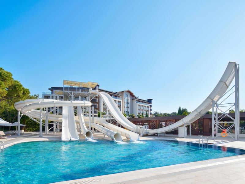 Venkovní vodní park s tobogány a bazénem pod jasnou modrou oblohou