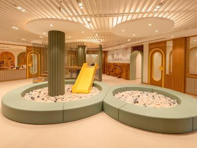 Amplio interior elegante con zona de asientos redonda y tobogán amarillo central.