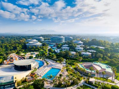 Ein großes Hotelresort mit mehreren Gebäuden, Pools und viel Grün in einer weitläufigen Landschaft.