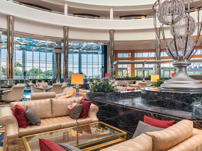 Große Hotellobby mit bequemen Sitzbereichen und großen Fenstern mit Aussicht.