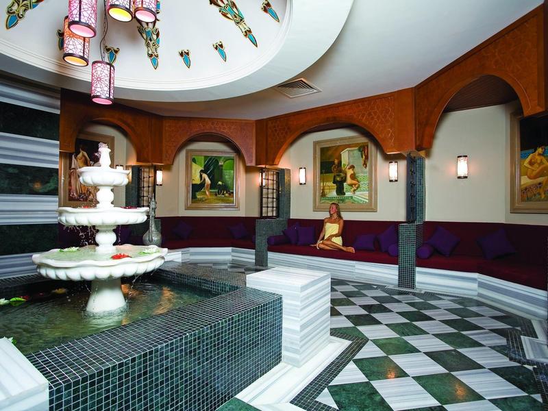 Elegante hotelhal met zwart-witte tegelvloer en grote fontein in het midden.