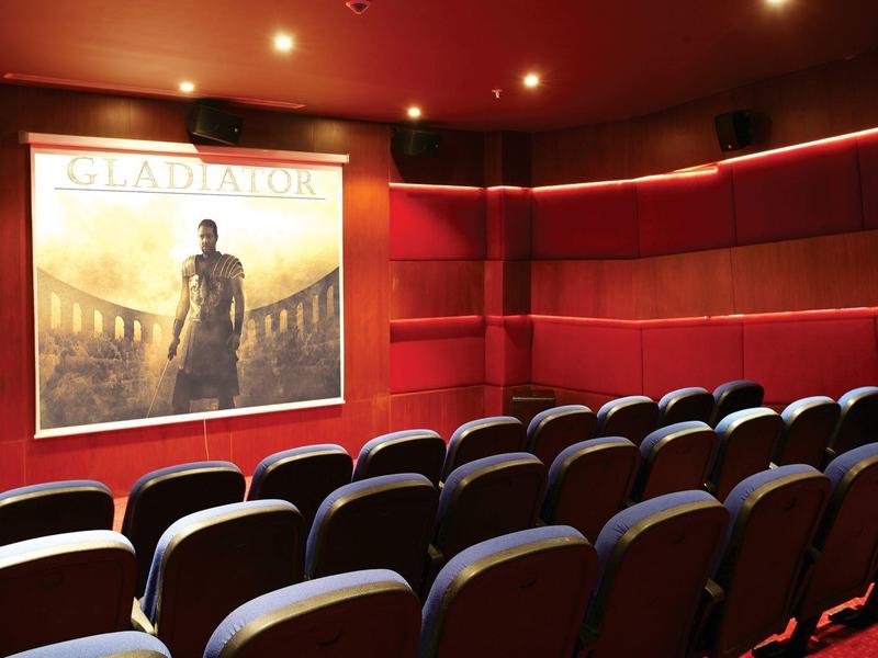 Twee mensen schudden elkaar de hand over een tennisnet op een buitenbaan met tennisballen op de grond.