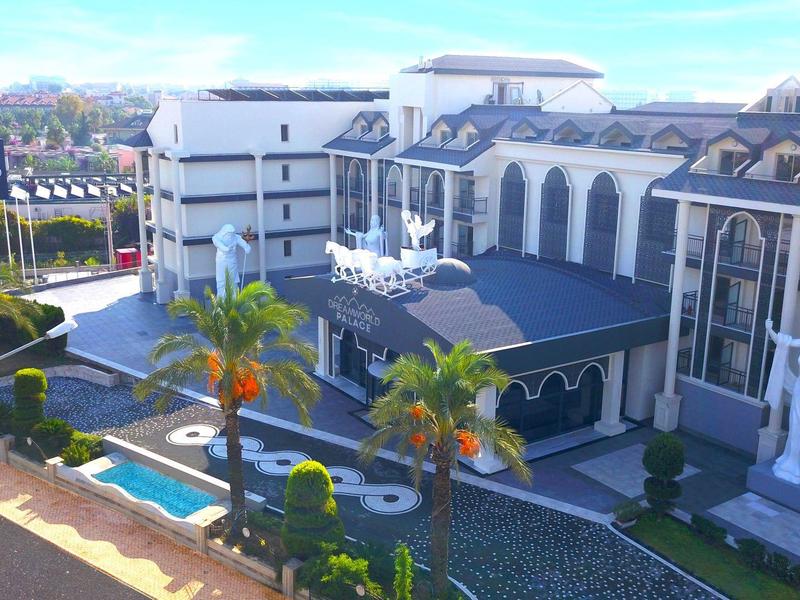 Hotel di lusso con piscina, palme e architettura moderna sotto il sole.