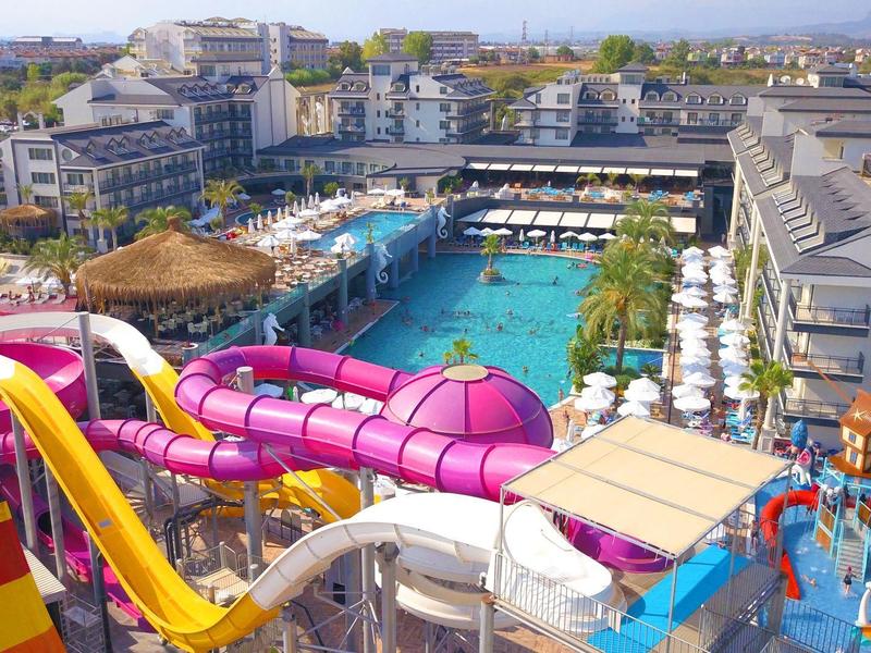 Parco acquatico con scivoli colorati e grande piscina in un complesso alberghiero.