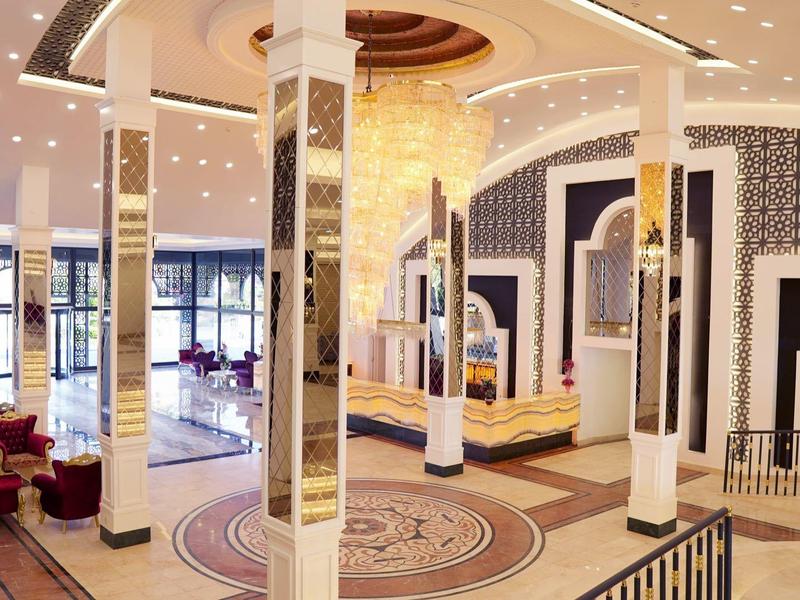 Ampia hall dell'hotel con design moderno, colonne bianche e aree salotto eleganti.