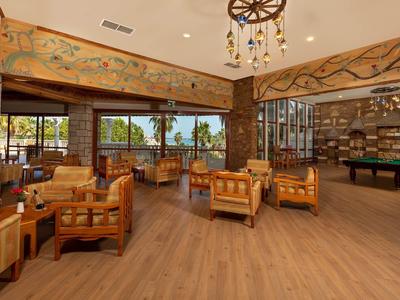 Lichte, ruime hotel-lounge met houten meubels, panoramische ramen en gezellige sfeer.