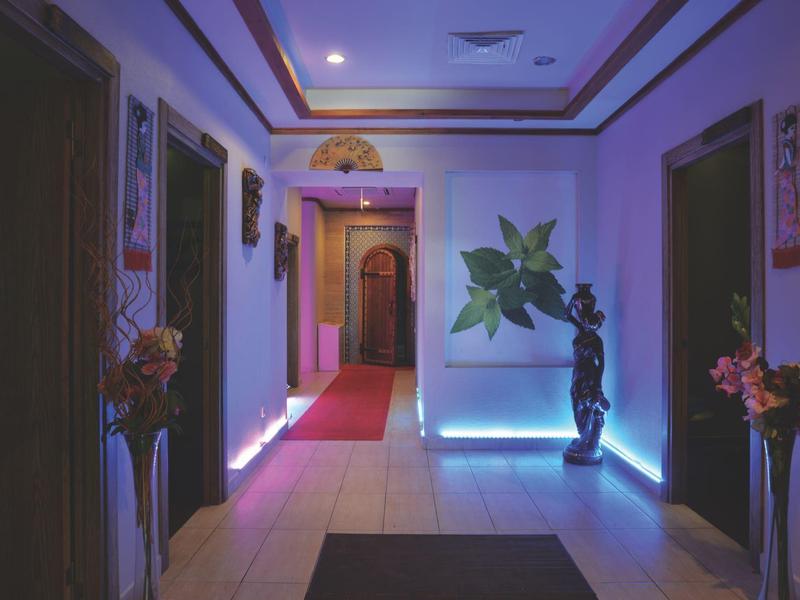 Hallway with soft lighting, decorations, and red carpets in a hotel.