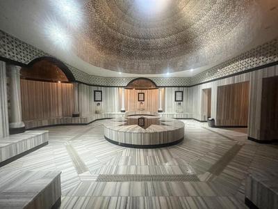 Duża, okrągła luksusowa strefa spa z marmurem i centralnym miejscem do siedzenia.