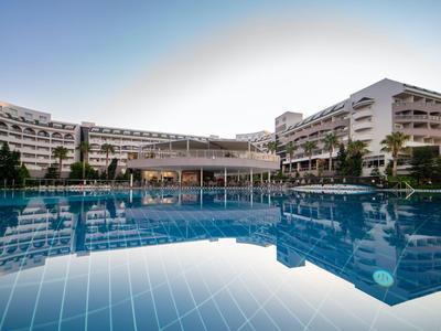 Duży hotel z odkrytym basenem i nowoczesną architekturą pod czystym niebem.