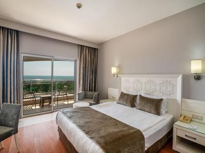 Nowoczesny pokój hotelowy z łóżkiem podwójnym, balkonem i widokiem na wybrzeże.