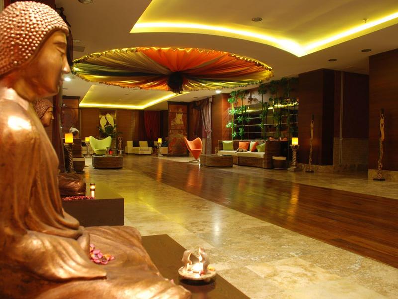 Przytulne lobby hotelowe z rzeźbą Buddy, dużą dekoracją i nowoczesnym oświetleniem.