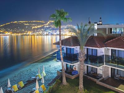 Hôtel en bord de mer la nuit avec côte illuminée et eau calme