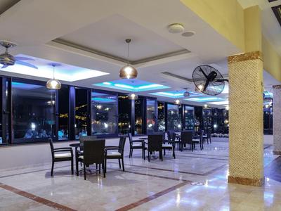 Intérieur élégant avec tables et chaises, éclairé par une lumière nocturne sombre.