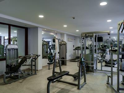 Modern gym with various exercise equipment in a bright room.