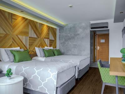 Chambre d'hôtel moderne avec deux lits, sol en bois et décoration murale.