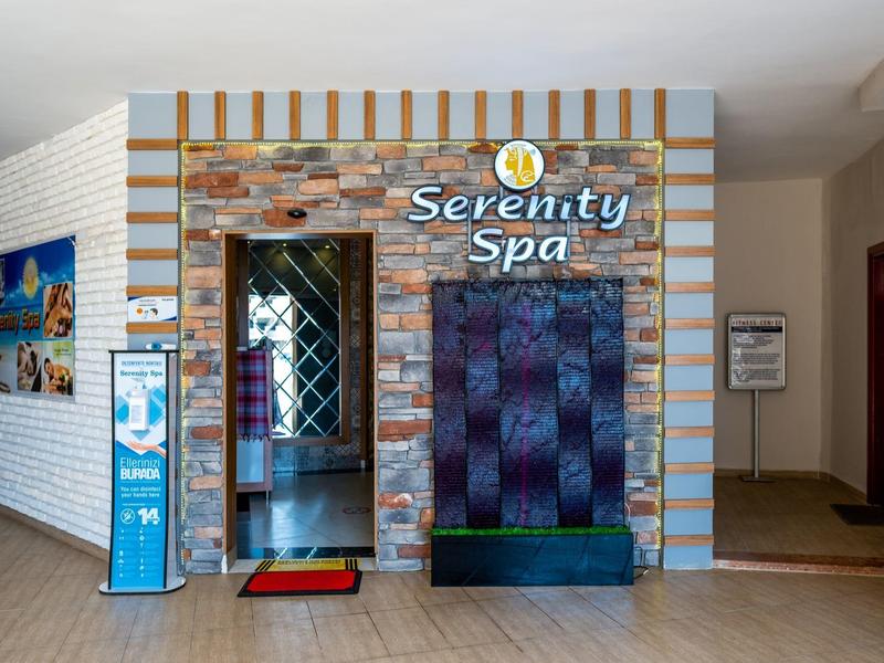 Entrée du Serenity Spa avec revêtement en bois et pierre dans un couloir d'hôtel.