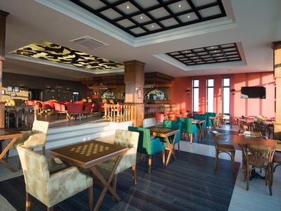 Interiér moderní hotelové restaurace s posezením a velkými okny