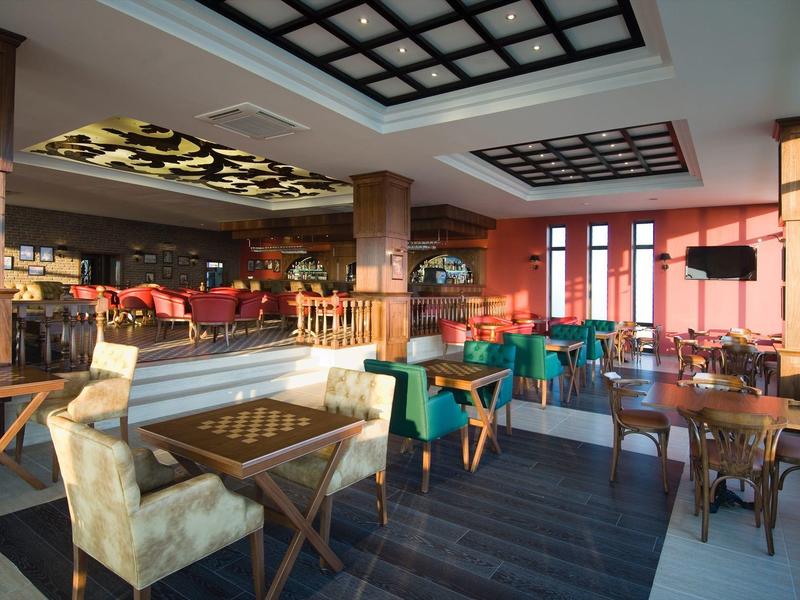 Interiér moderní hotelové restaurace s posezením a velkými okny