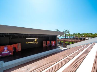 Moderne terras met houten traptreden en reclamepanelen in een zonnig buitengebied.