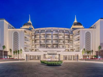 Indrukwekkend, verlicht luxe hotel met symmetrische architectuur en koepeldaken bij schemering.