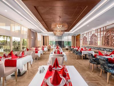 Elegant restaurant with white tables and red decorations in a modern setting.